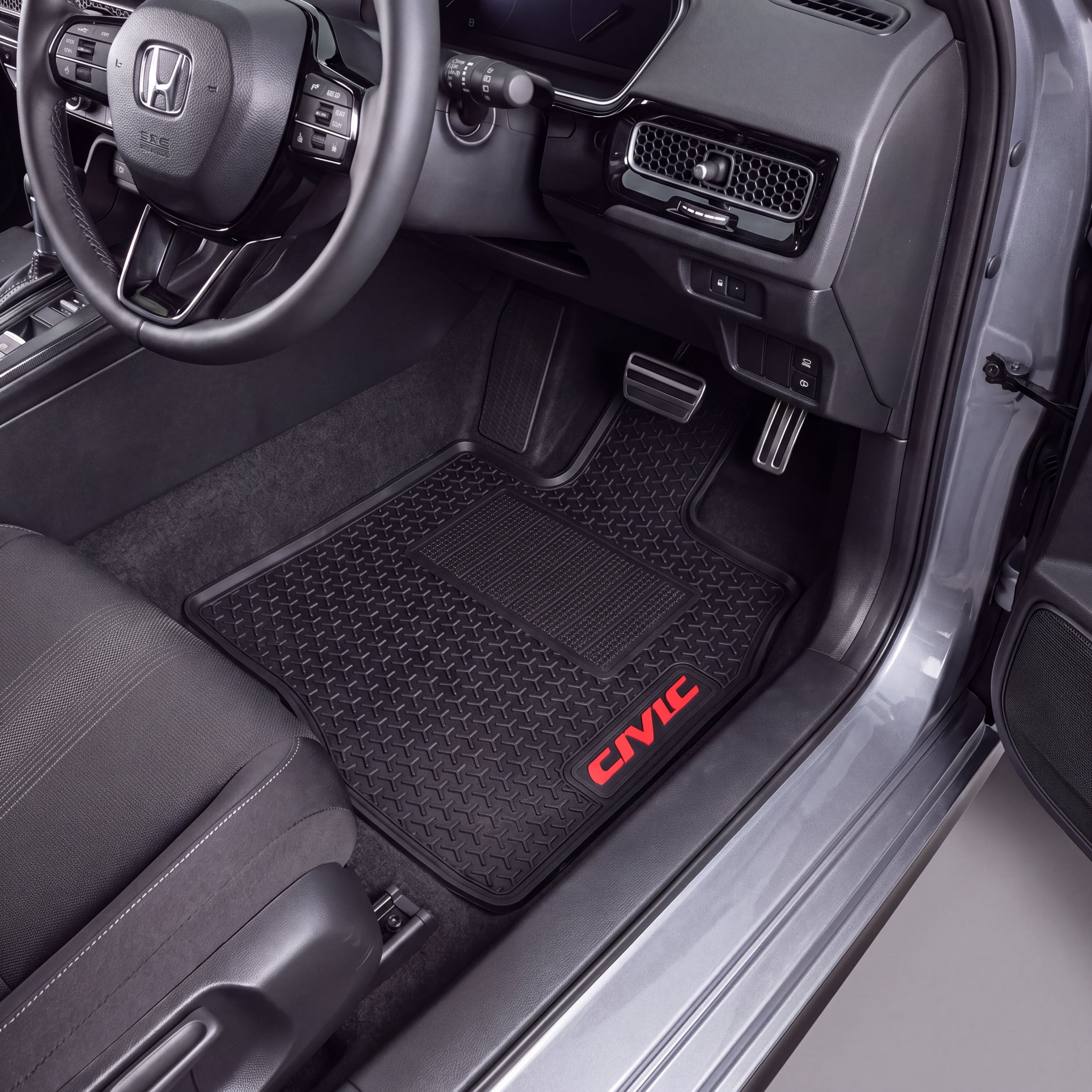 Black rubber car floor mats installed in a Honda Civic, featuring a diamond-embossed pattern and a red embroidered 'CIVIC' logo on the driver's side mat.