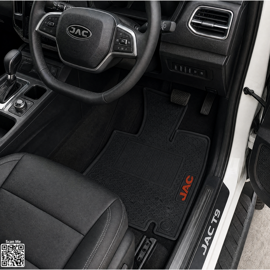 Black JAC T9 driver's side car floor mat installed inside a vehicle cabin, shown with the steering wheel, dashboard, and door sill visible. The mat has a red JAC logo and the text 'JAC T9' on the door sill.