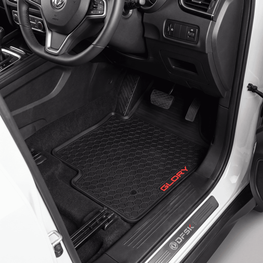Black car floor mats installed in a vehicle interior, with the driver-side mat showing a red 'GLORY' logo and the door sill showing a 'DFSK' brand mark.