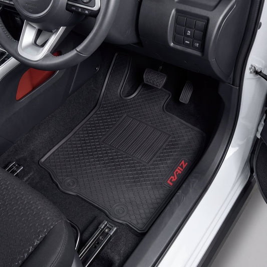Black car floor mats with a diamond-embossed pattern and a red 'RAIZE' logo, shown installed inside a vehicle's driver's side footwell.