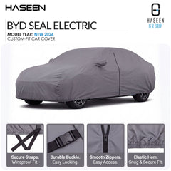 A gray car cover fitted over a sedan, shown on a white background with HASEEN branding and feature callouts. The image includes text reading 'BYD SEAL ELECTRIC', 'MODEL YEAR: NEW 2026', and four small inset detail images at the bottom highlighting straps, buckle, zippers, and hem.