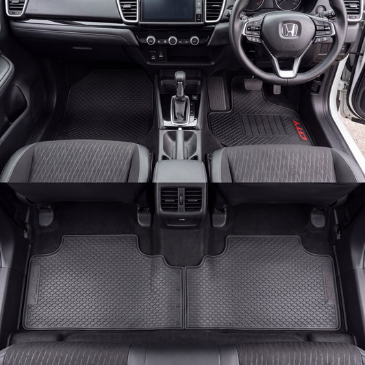 Black textured car floor mats installed in the front and rear of a Honda vehicle interior, shown from above with the seats and dashboard visible.