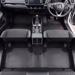Black textured car floor mats installed in the front and rear of a Honda vehicle interior, shown from above with the seats and dashboard visible.