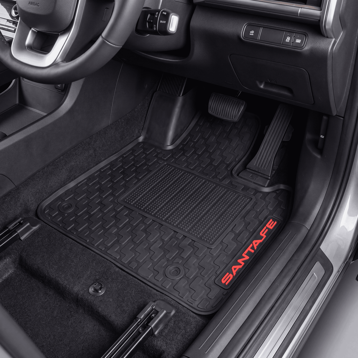 Black rubber car floor mats installed in a vehicle interior, with red SANTATE branding on the side of one mat.