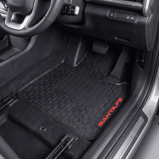 Black rubber car floor mats installed in a vehicle interior, with red SANTATE branding on the side of one mat.