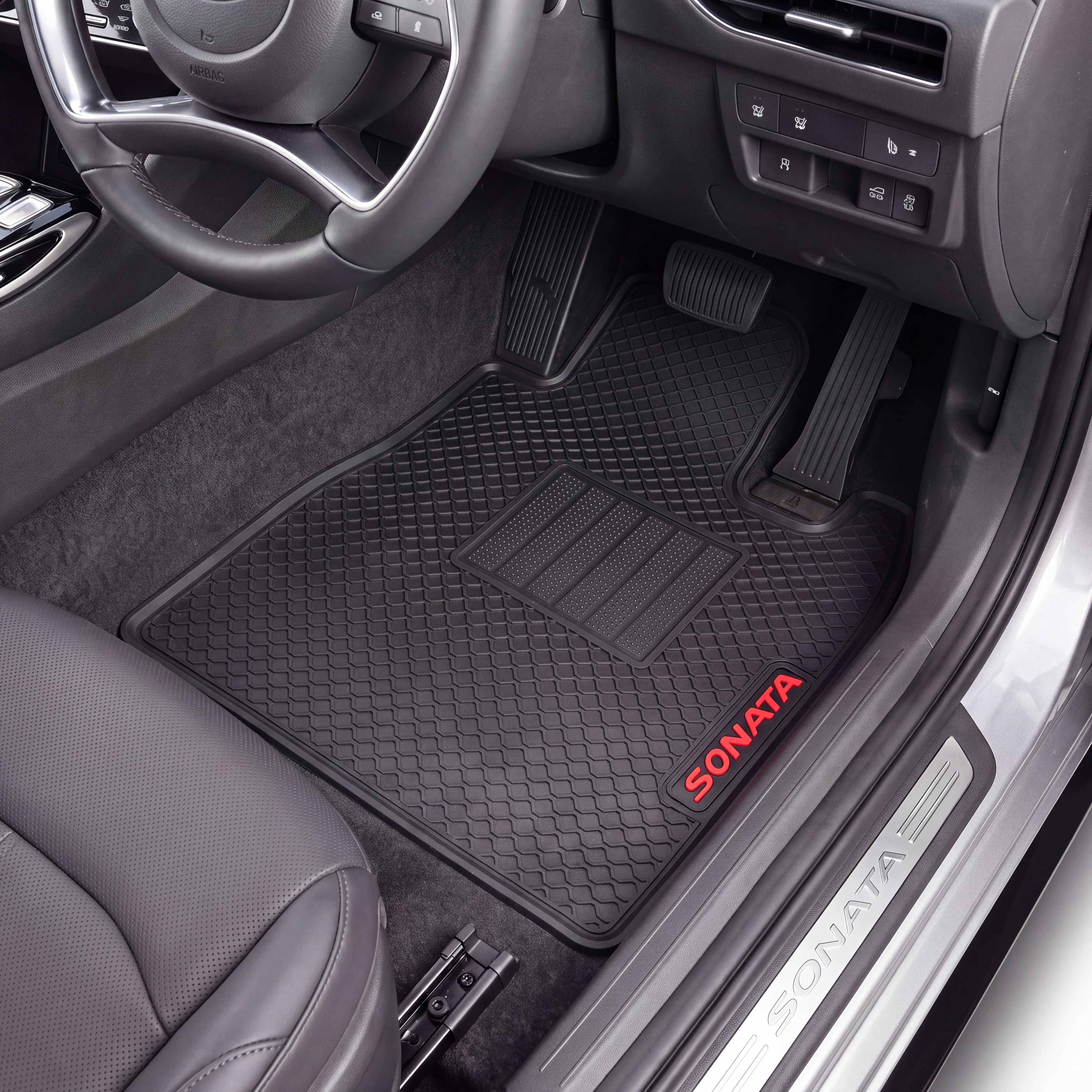 Black Sonata brand rubber car floor mats installed in the front passenger and driver footwells of a gray vehicle, with the door sill also showing the Sonata logo.