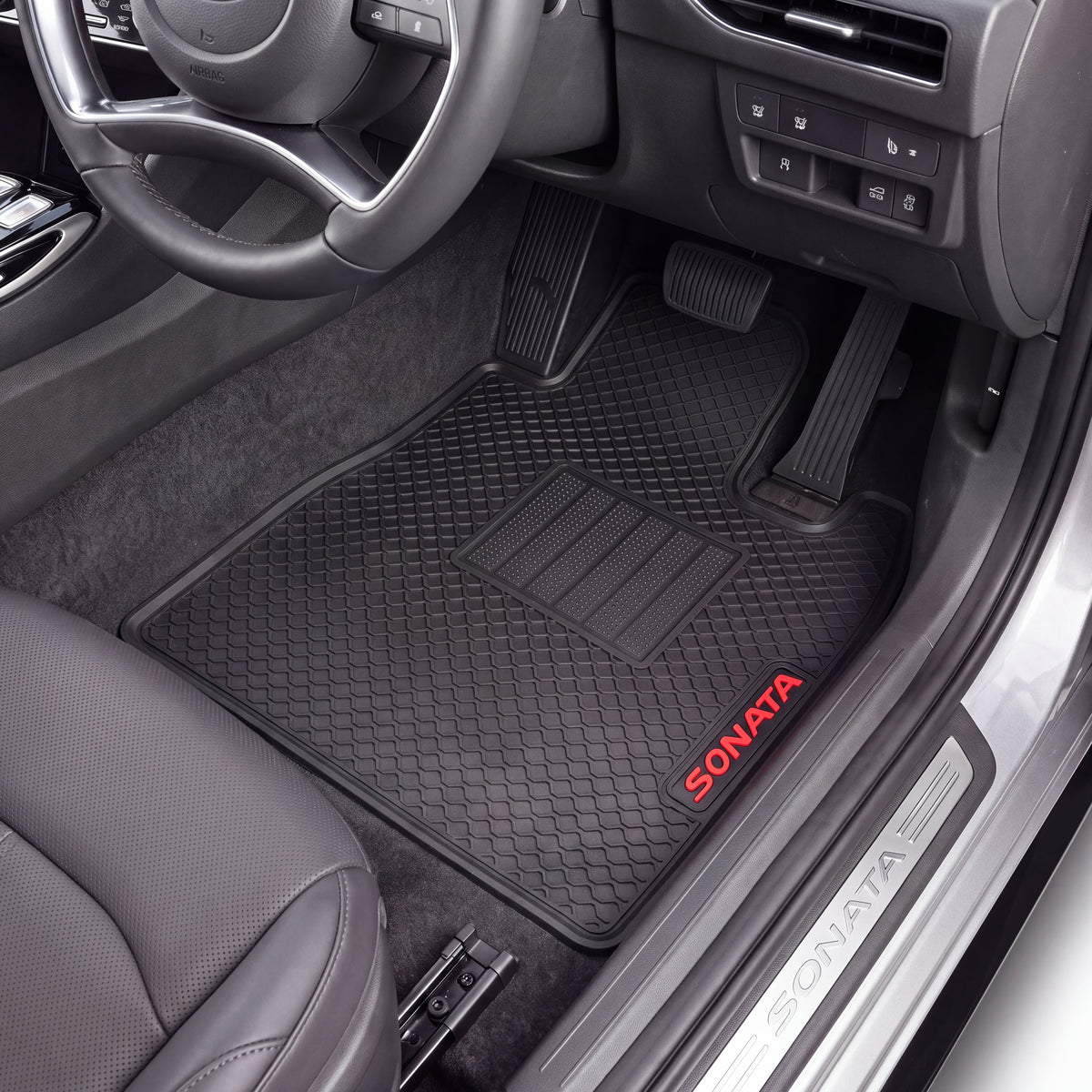 Black Sonata brand rubber car floor mats installed in the front passenger and driver footwells of a gray vehicle, with the door sill also showing the Sonata logo.