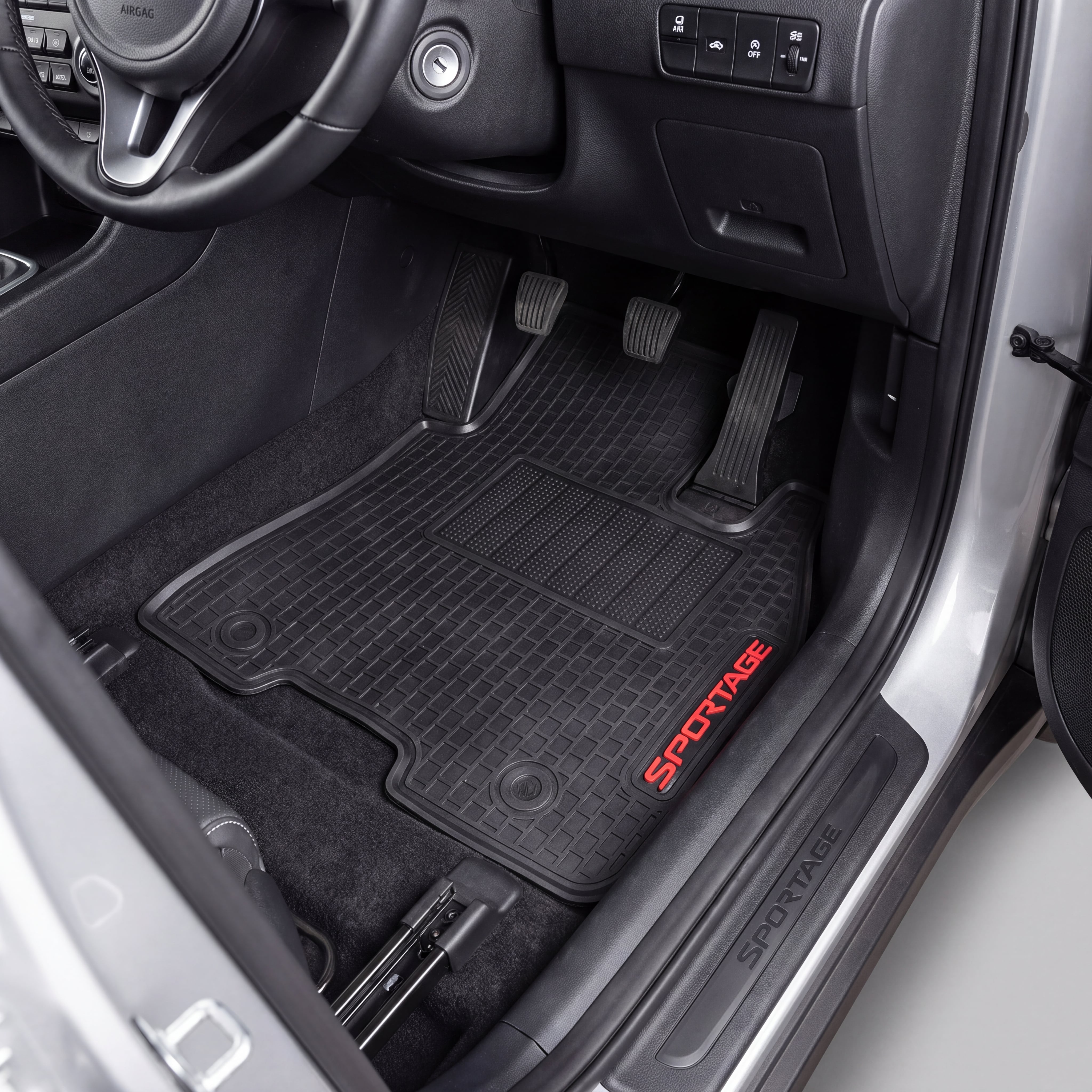 Black car floor mats with red SPORTAGE lettering, shown installed inside a vehicle's footwell next to the open door.