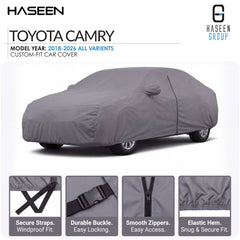 A gray custom-fit car cover shown fitted over a Toyota Camry, with text at the top stating model year 2018-2026 all variants and feature callouts along the bottom including secure straps, durable buckle, smooth zippers, and elastic hem.