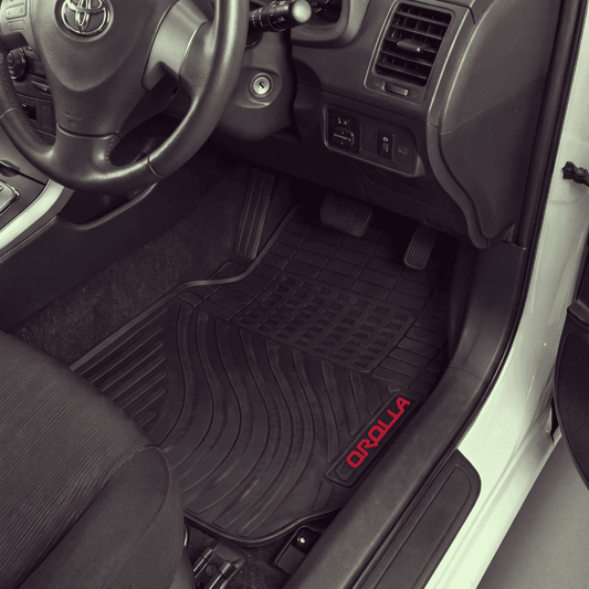 Black rubber car floor mats installed in the front cabin of a Toyota vehicle, with the driver's side mat showing a red 'ORILLA' logo near the bottom corner.